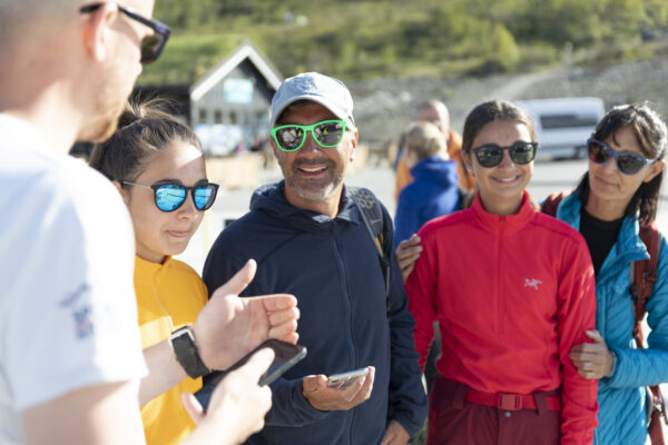 glade fjellfolk som skal gå tur over besseggen